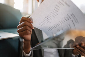 Close-up of African American businesswoman going through financial reports.