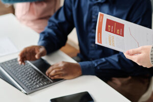 Selective focus high angle view of African American man and his unrecognizable female coworkers discussing new business strategy at work